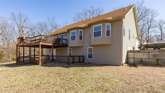 rear view of property with a deck and a yard