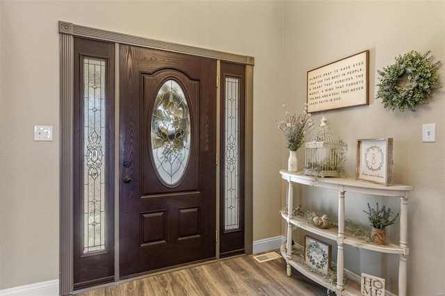 entryway with wood finished floors and baseboards