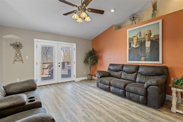 living area featuring a ceiling fan, wood finished floors, french doors, baseboards, and vaulted ceiling