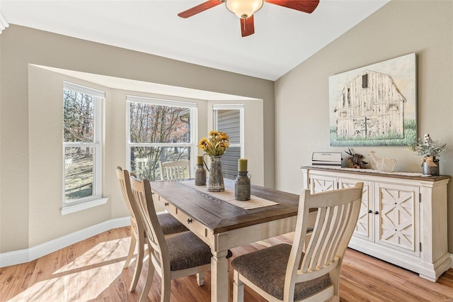 dining room with vaulted ceiling, baseboards, light wood-type flooring, and ceiling fan