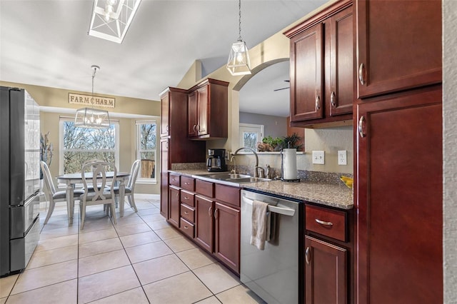 kitchen featuring a sink, reddish brown cabinets, appliances with stainless steel finishes, and light tile patterned floors