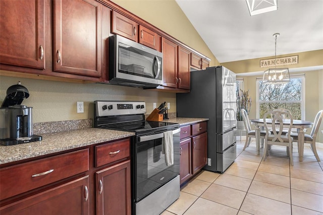 kitchen with dark brown cabinets, decorative light fixtures, vaulted ceiling, light tile patterned floors, and stainless steel appliances