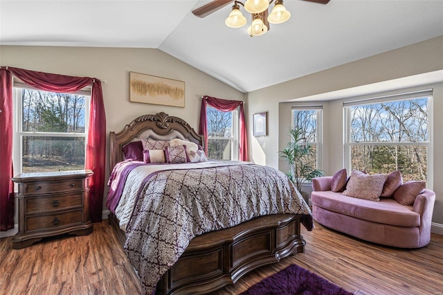 bedroom featuring vaulted ceiling, multiple windows, wood finished floors, and ceiling fan