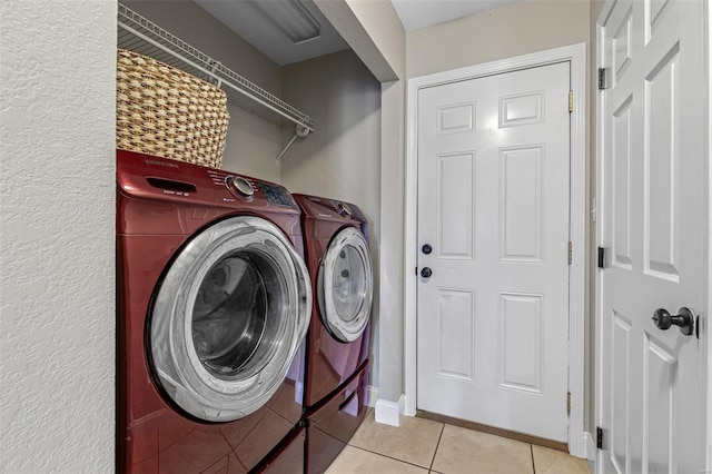 laundry area with light tile patterned flooring, laundry area, independent washer and dryer, and baseboards