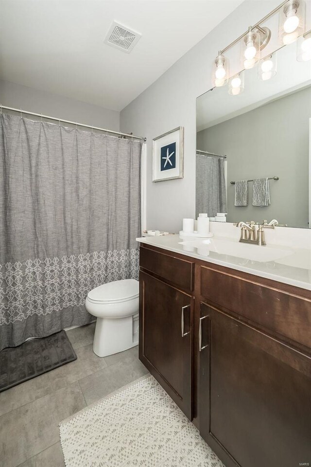 bathroom featuring vanity, tile patterned floors, toilet, and visible vents