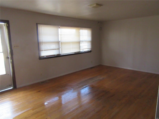 empty room featuring wood finished floors and visible vents