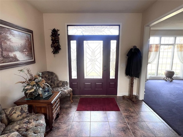 carpeted foyer entrance featuring baseboards