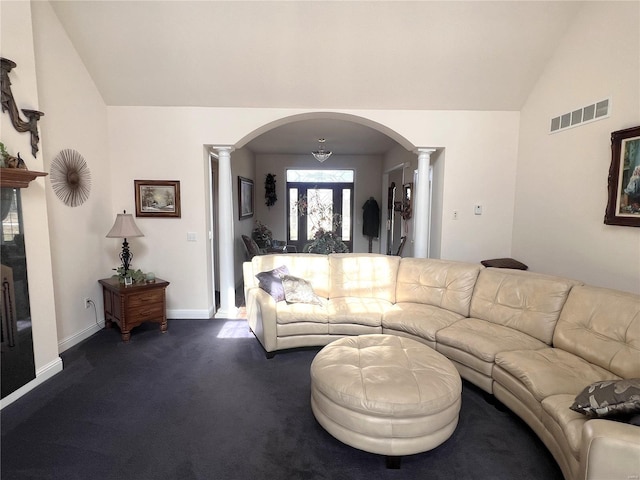 living room featuring dark colored carpet, visible vents, vaulted ceiling, and ornate columns