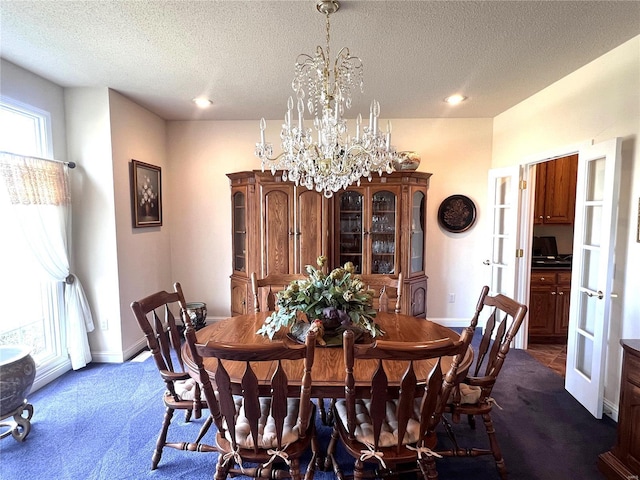 dining space featuring dark colored carpet, french doors, a notable chandelier, and a textured ceiling