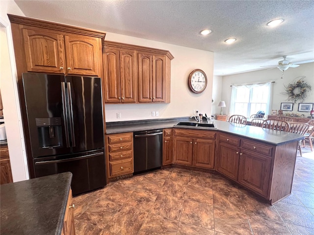 kitchen featuring dark countertops, black refrigerator with ice dispenser, a sink, dishwasher, and a peninsula