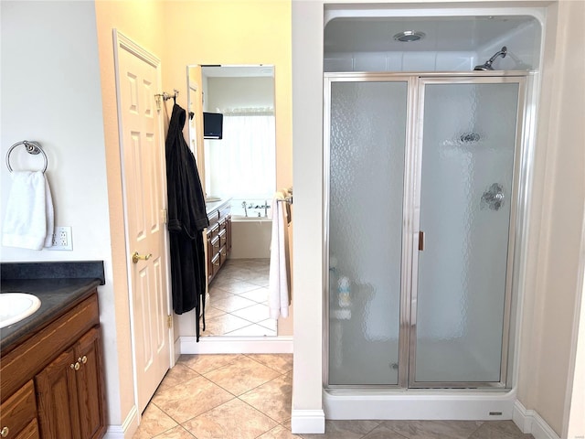 full bathroom featuring a stall shower, tile patterned flooring, and vanity