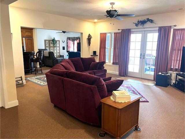 carpeted living area featuring ceiling fan, visible vents, and french doors