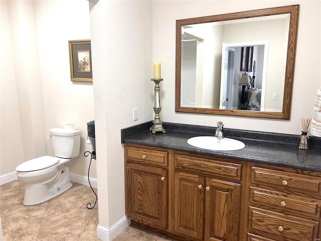 bathroom with vanity, toilet, and baseboards