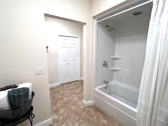 bathroom featuring baseboards and shower / bath combo with shower curtain