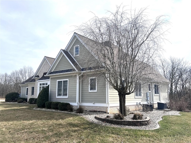 view of side of property featuring a lawn and central AC unit