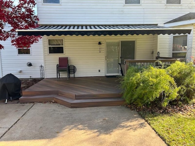 property entrance with a wooden deck and metal roof