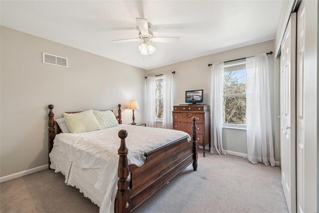 bedroom with visible vents, light colored carpet, and baseboards