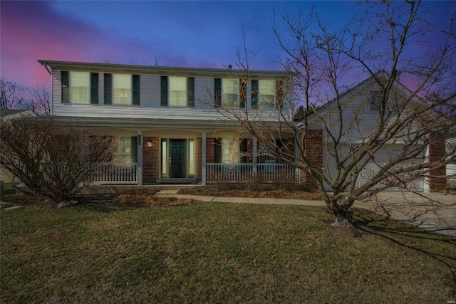 view of front of house with a front yard, a porch, concrete driveway, a garage, and brick siding