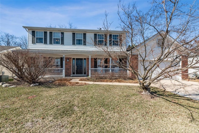 view of front of home with brick siding, covered porch, driveway, and a front yard