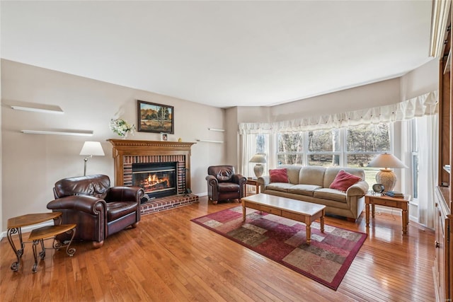 living area with a fireplace, baseboards, and wood-type flooring