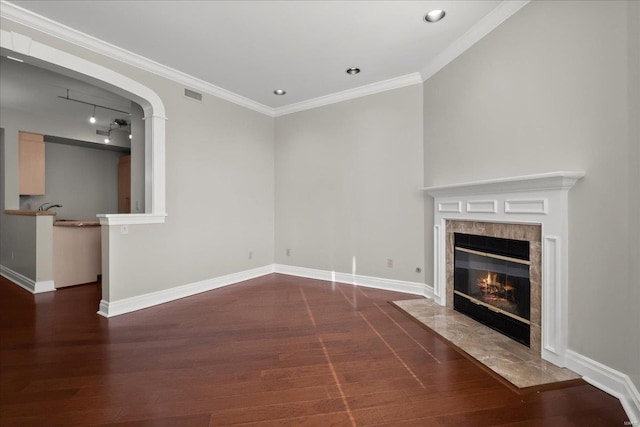 unfurnished living room with a premium fireplace, wood finished floors, visible vents, and baseboards