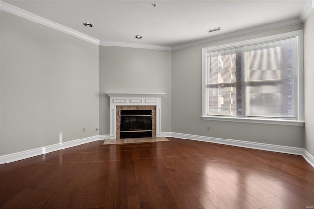 unfurnished living room featuring crown molding, a fireplace, baseboards, and wood finished floors