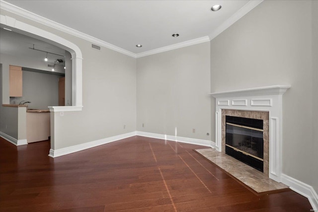 unfurnished living room with ornamental molding, visible vents, baseboards, and wood finished floors