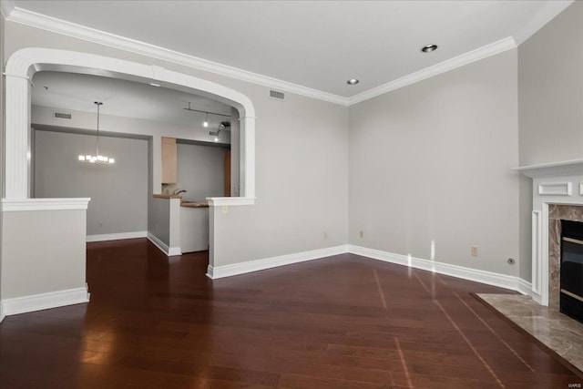 unfurnished living room with ornamental molding, wood finished floors, a high end fireplace, and baseboards