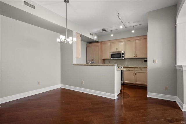 kitchen with dark wood-style floors, stainless steel microwave, backsplash, light brown cabinetry, and baseboards