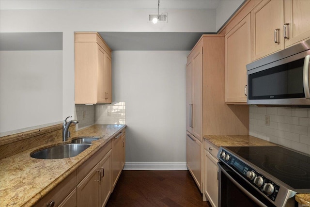 kitchen with light stone counters, electric stove, stainless steel microwave, visible vents, and a sink