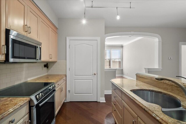 kitchen featuring dark wood-type flooring, electric range, a sink, tasteful backsplash, and stainless steel microwave