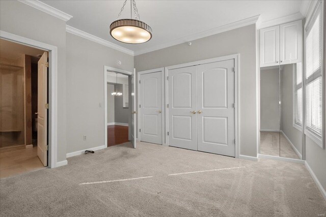 unfurnished bedroom with baseboards, ornamental molding, ensuite bathroom, and light colored carpet