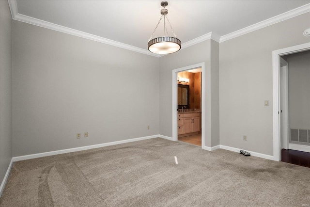 unfurnished bedroom featuring connected bathroom, light colored carpet, visible vents, baseboards, and crown molding