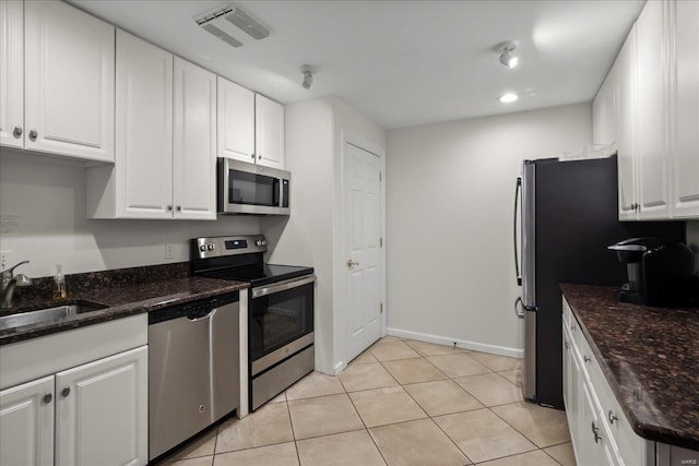 kitchen with appliances with stainless steel finishes, a sink, visible vents, and white cabinetry