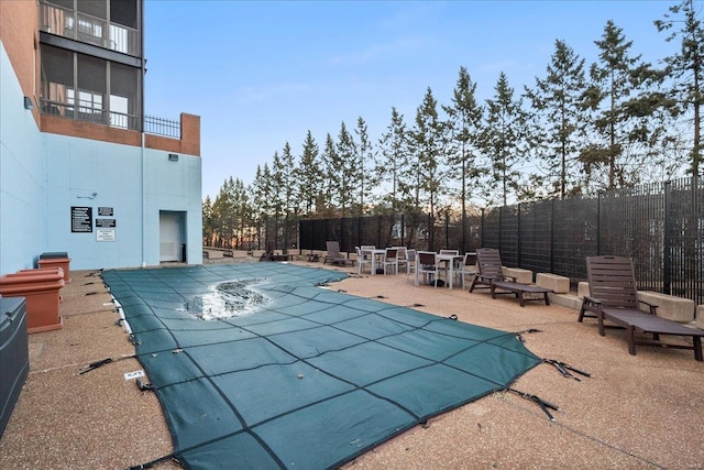 community pool featuring fence and a patio