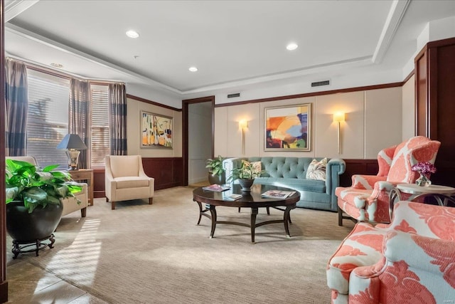 living room with a raised ceiling, light colored carpet, visible vents, and a decorative wall