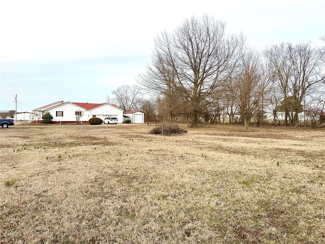 view of yard featuring a garage and an outbuilding