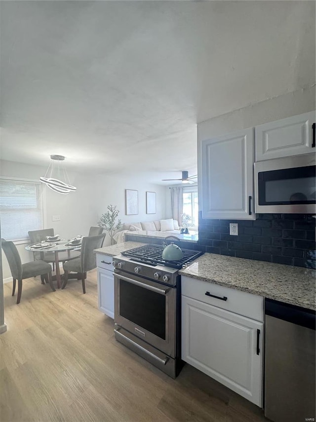 kitchen featuring white cabinetry, stainless steel appliances, and wood finished floors