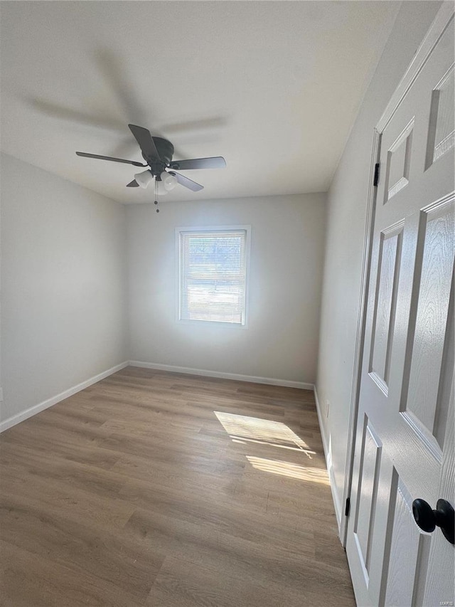 unfurnished room featuring a ceiling fan, baseboards, and wood finished floors