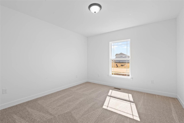 empty room with carpet, baseboards, and visible vents