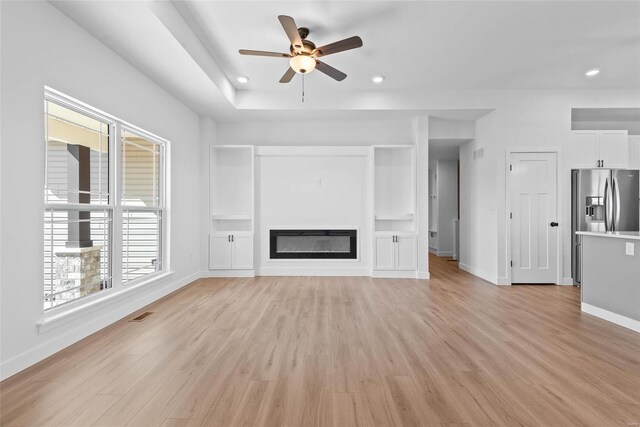 unfurnished living room featuring baseboards, a ceiling fan, a glass covered fireplace, light wood-style flooring, and recessed lighting