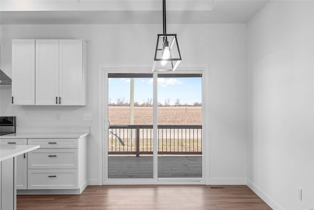 unfurnished dining area with wood finished floors and baseboards