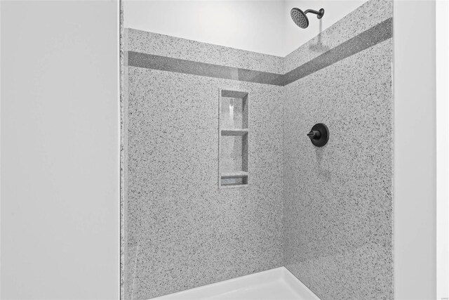 interior details with a tile shower