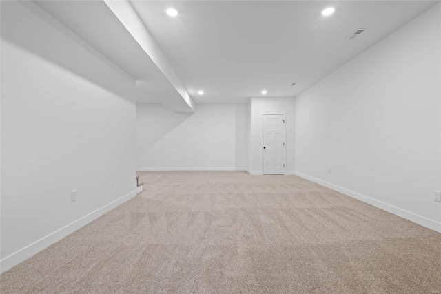 empty room with light carpet, baseboards, and recessed lighting