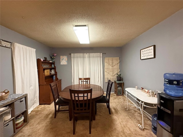 dining area with light carpet and a textured ceiling