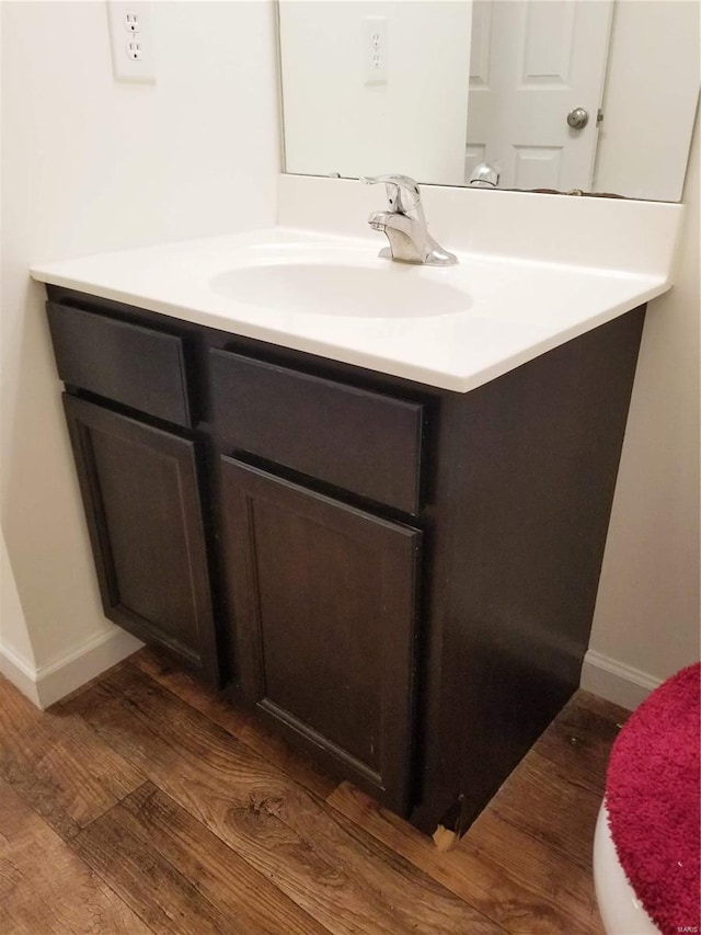 bathroom featuring vanity, baseboards, and wood finished floors