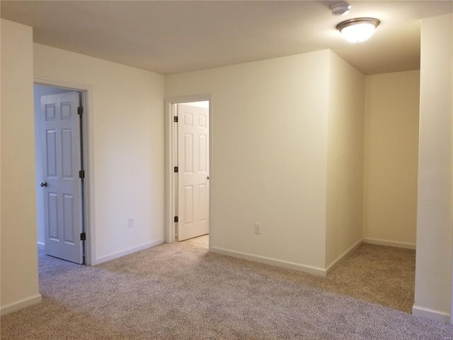 spare room with baseboards and carpet flooring