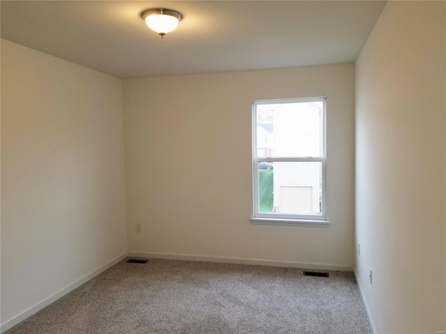 carpeted empty room with visible vents and baseboards