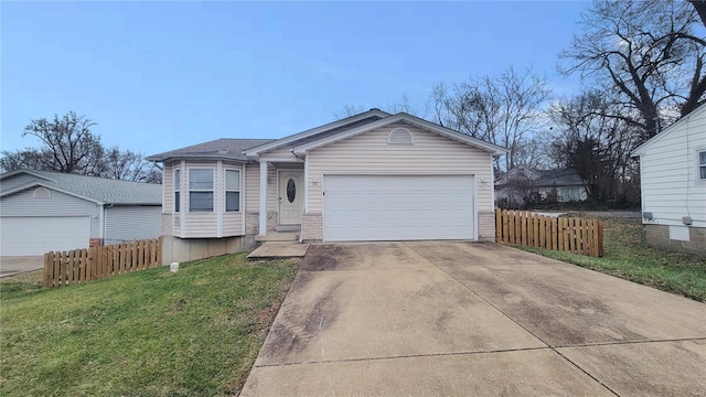 view of front of house with a front yard, fence, driveway, and an attached garage