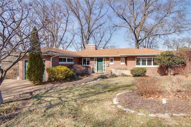 single story home with a front lawn, brick siding, driveway, and a chimney